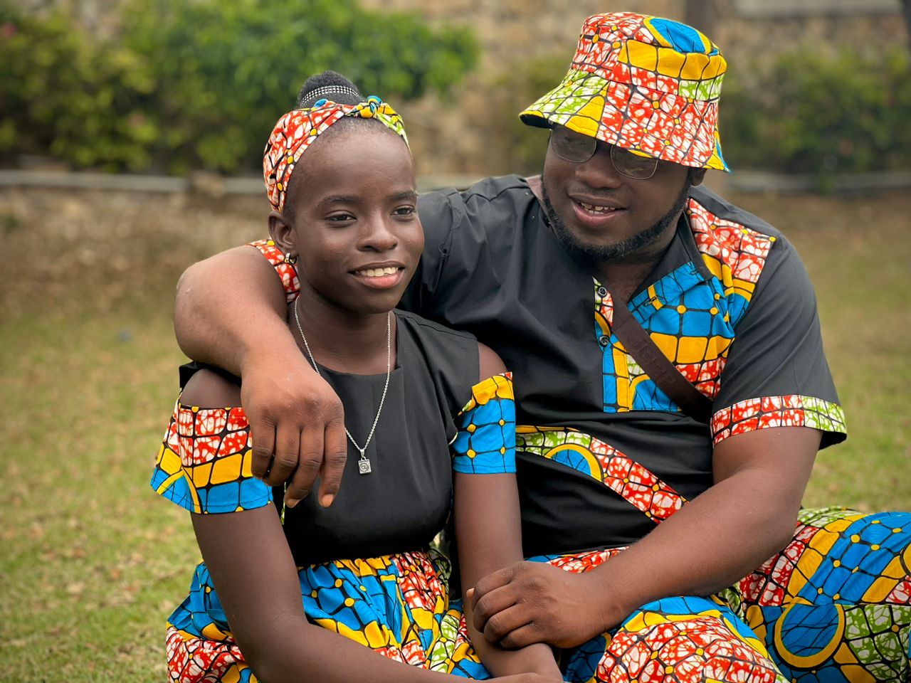 Fr. Luckson et une enfant en tenue assortie