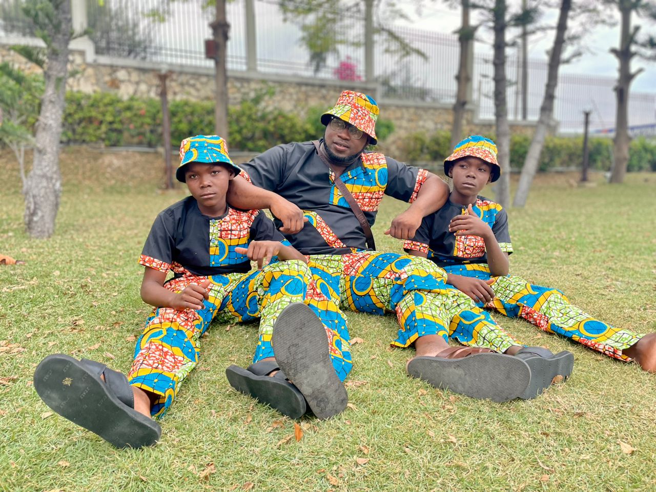 Fr. Luckson et deux garçons en tenue traditionnelle